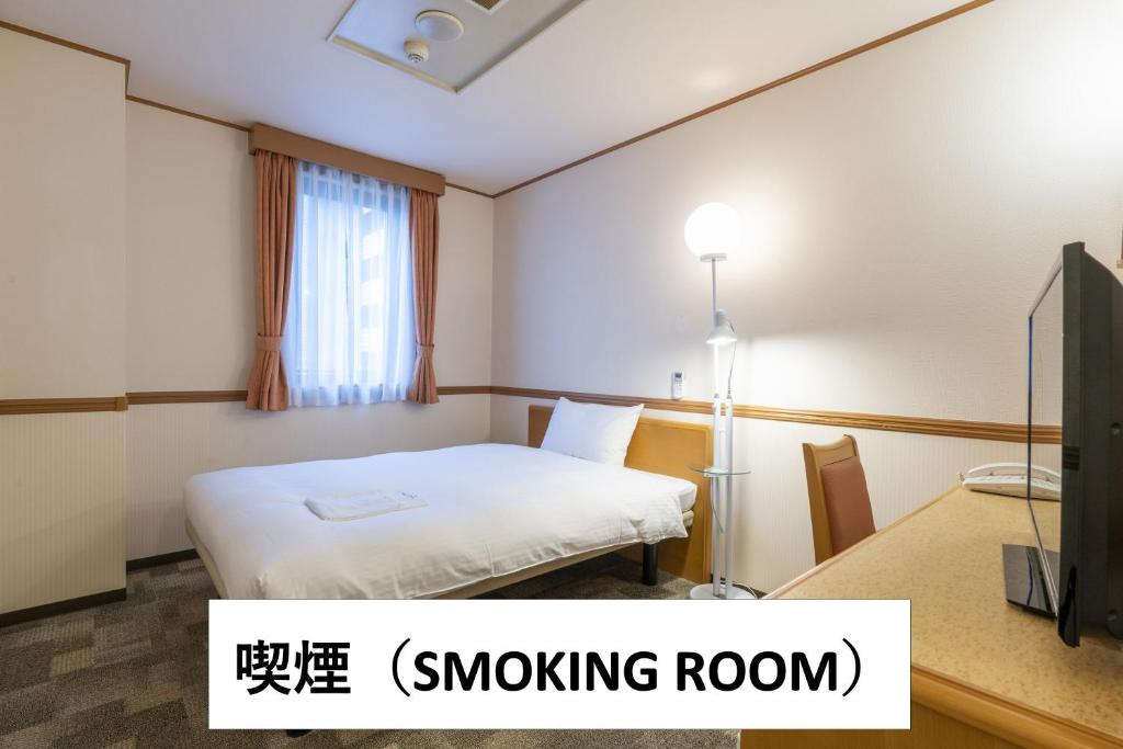 a hotel room with a bed and a tv at Hotel Endear Gifu in Gifu