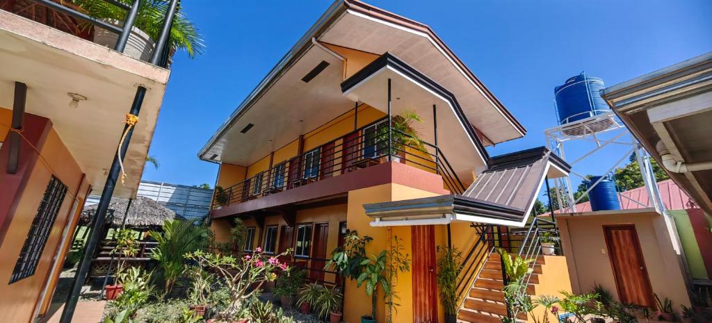 Dieses gelbe und orangefarbene Gebäude verfügt über einen Balkon. in der Unterkunft OYO 1065 Summer Wind Pension in Puerto Princesa