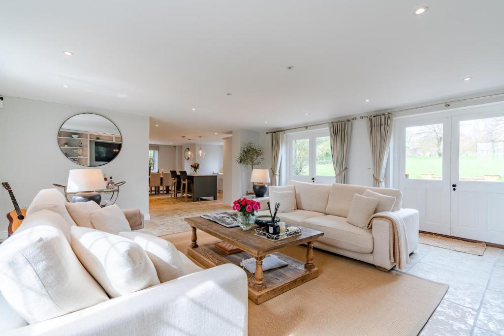 een woonkamer met twee witte banken en een tafel bij Old Manse in Burford