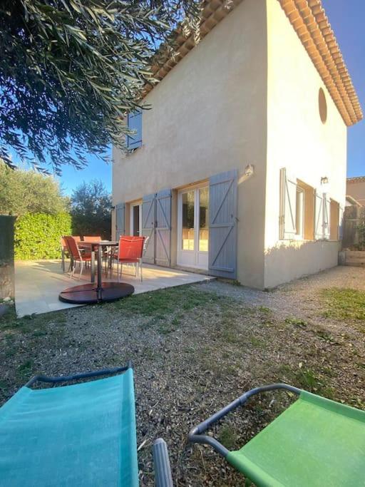 une maison avec une table et des chaises dans la cour dans l'établissement Le gite du defend, à Salernes