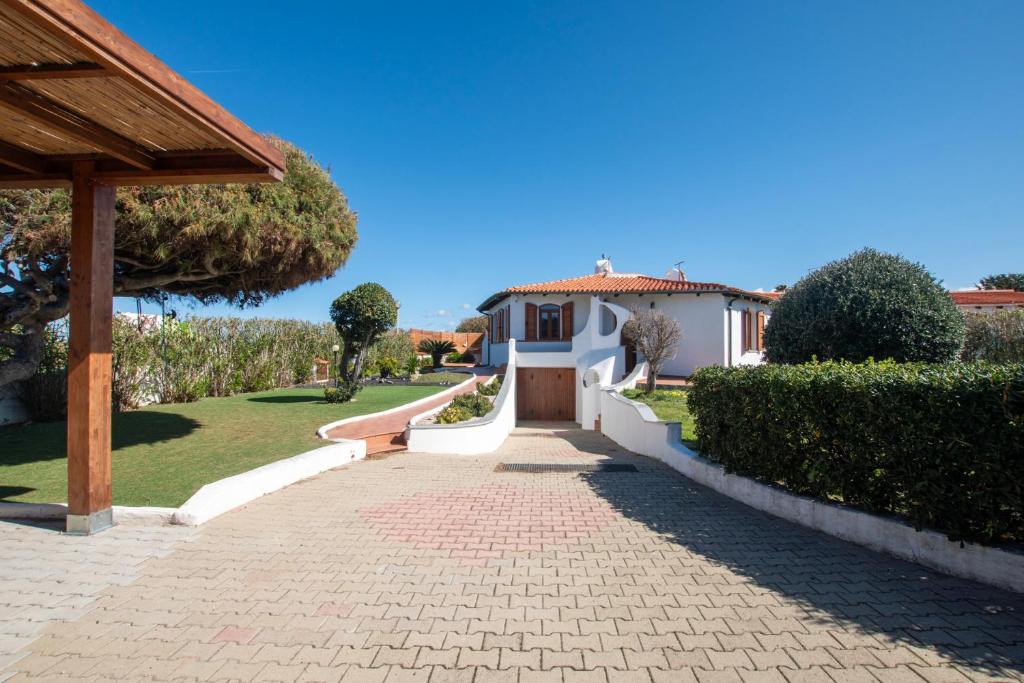 een oprit die leidt naar een huis met een tuin bij Villa Onda in Valledoria