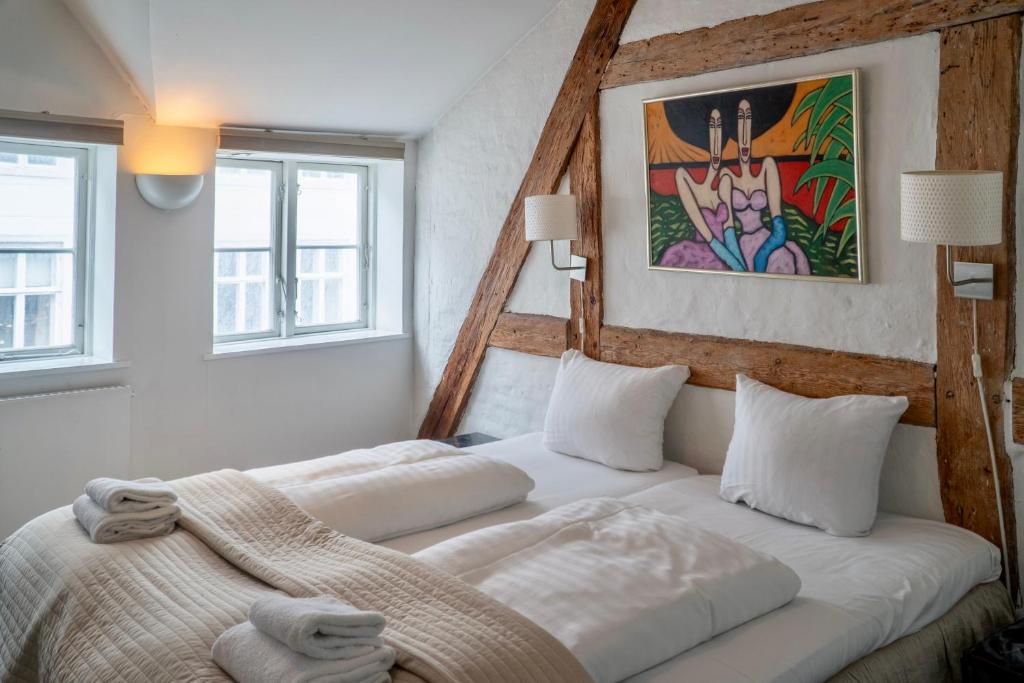 sypialnia z 2 łóżkami i obrazem na ścianie w obiekcie Brooklyn Penthouse w Kopenhadze