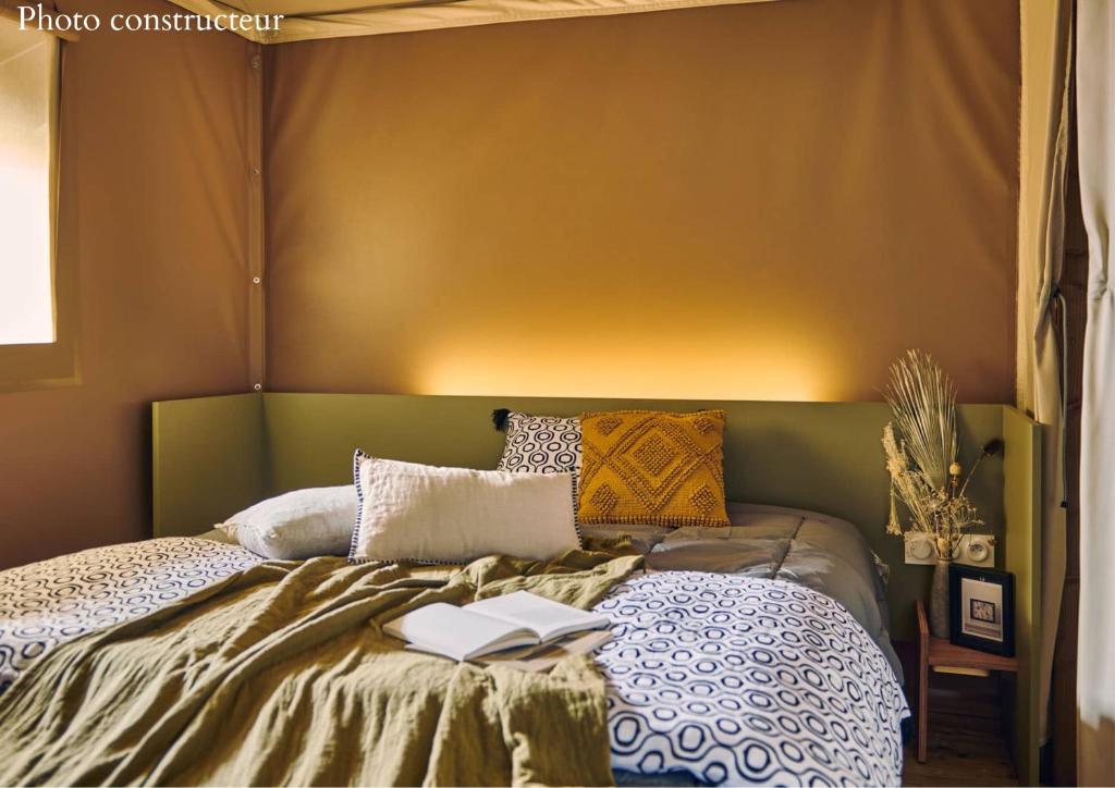 - une chambre avec un lit et 2 livres dans l'établissement Village Camping La Roseraie, à La Baule