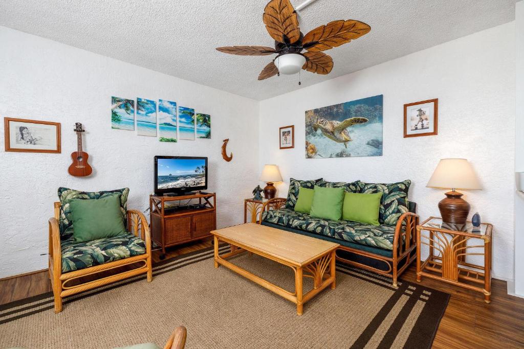 a living room with two couches and a tv at Alii Villas 340 in Kailua-Kona