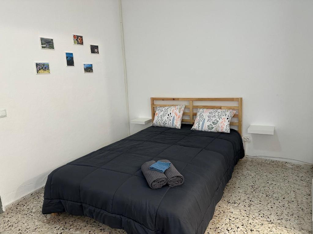 ein Schlafzimmer mit einem Bett mit zwei Hausschuhen darauf in der Unterkunft Apartamento C san Jose de los Llanos in San Jose De Los Llanos