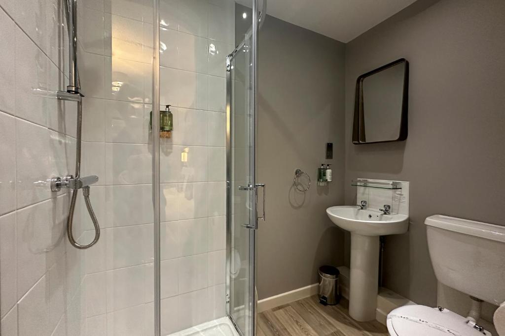 a bathroom with a shower and a toilet and a sink at The Lobster in Sheringham