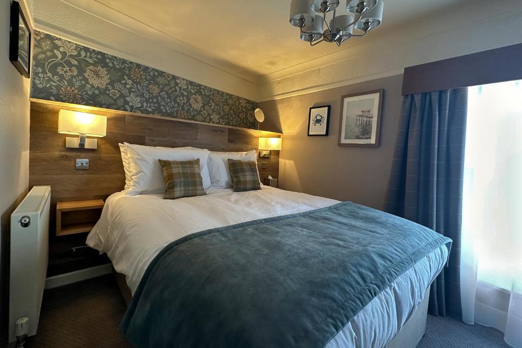 a hotel room with a bed and a window at The Lobster in Sheringham
