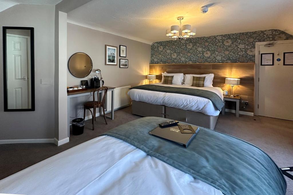a hotel room with two beds and a desk at The Lobster in Sheringham