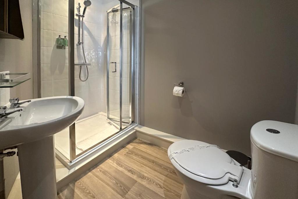 a bathroom with a shower and a toilet and a sink at The Lobster in Sheringham