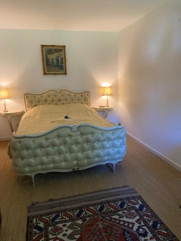 a bed in a bedroom with two lamps and a rug at Domaine de l'Atrée - Chambre d'hôtes suite familiale in Saint-Martin-des-Champs