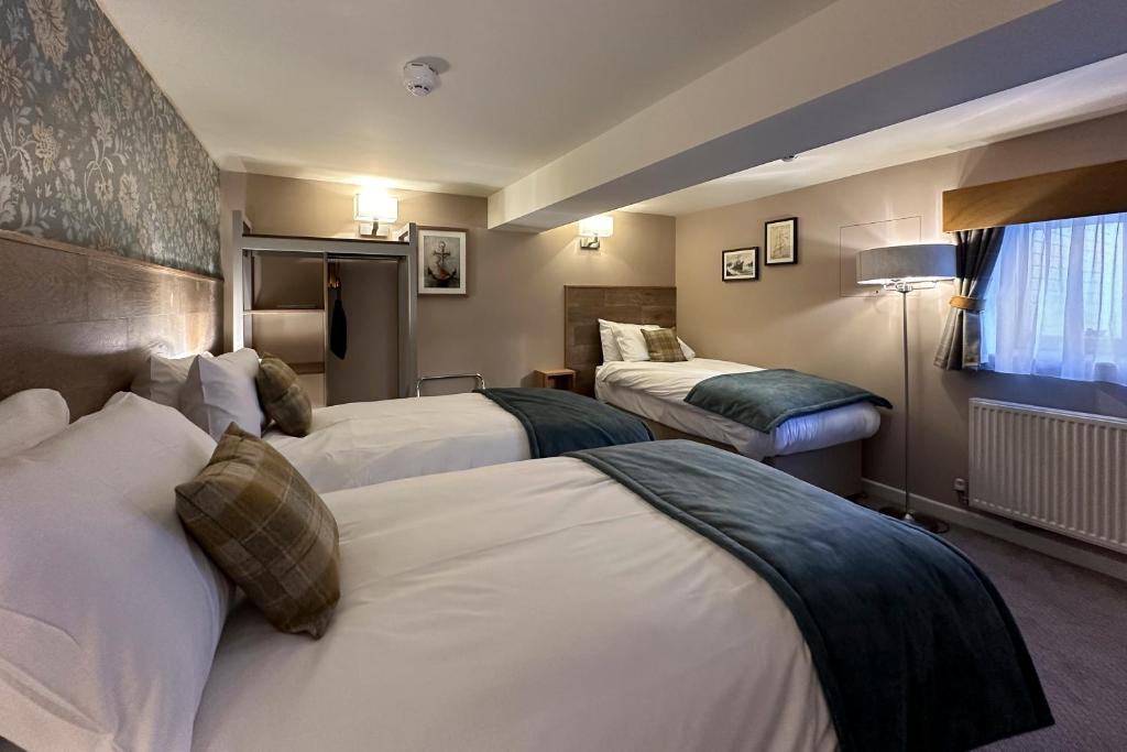 a hotel room with two beds and a window at The Lobster in Sheringham