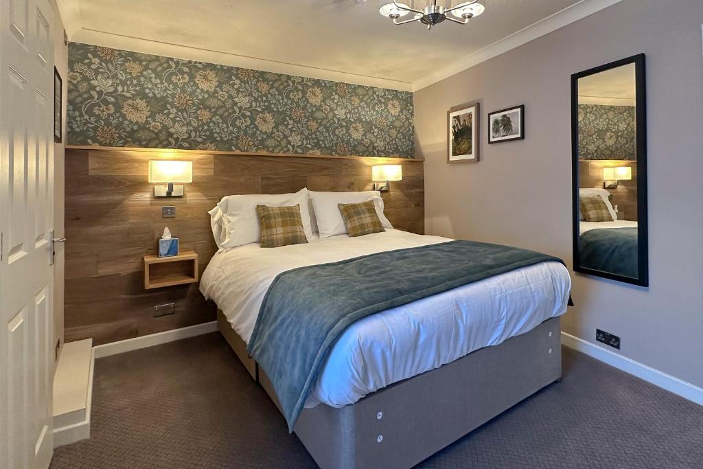 a bedroom with a large bed and a mirror at The Lobster in Sheringham