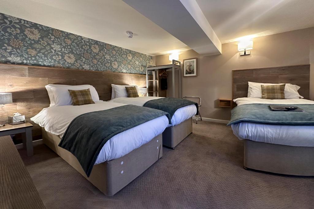 a hotel room with two beds and a desk at The Lobster in Sheringham