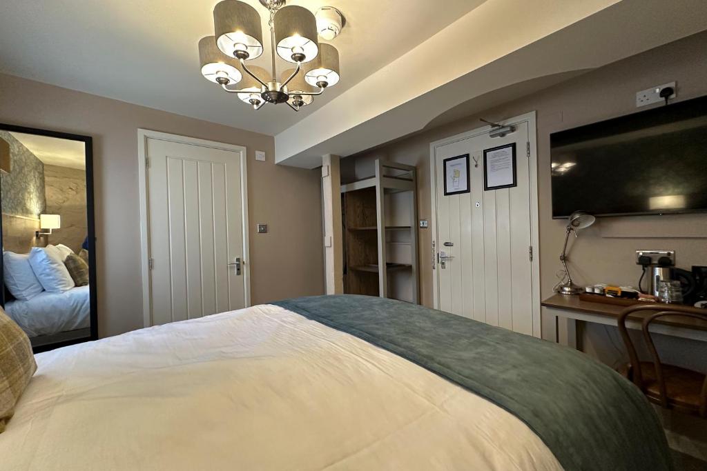 a bedroom with a large bed and a chandelier at The Lobster in Sheringham