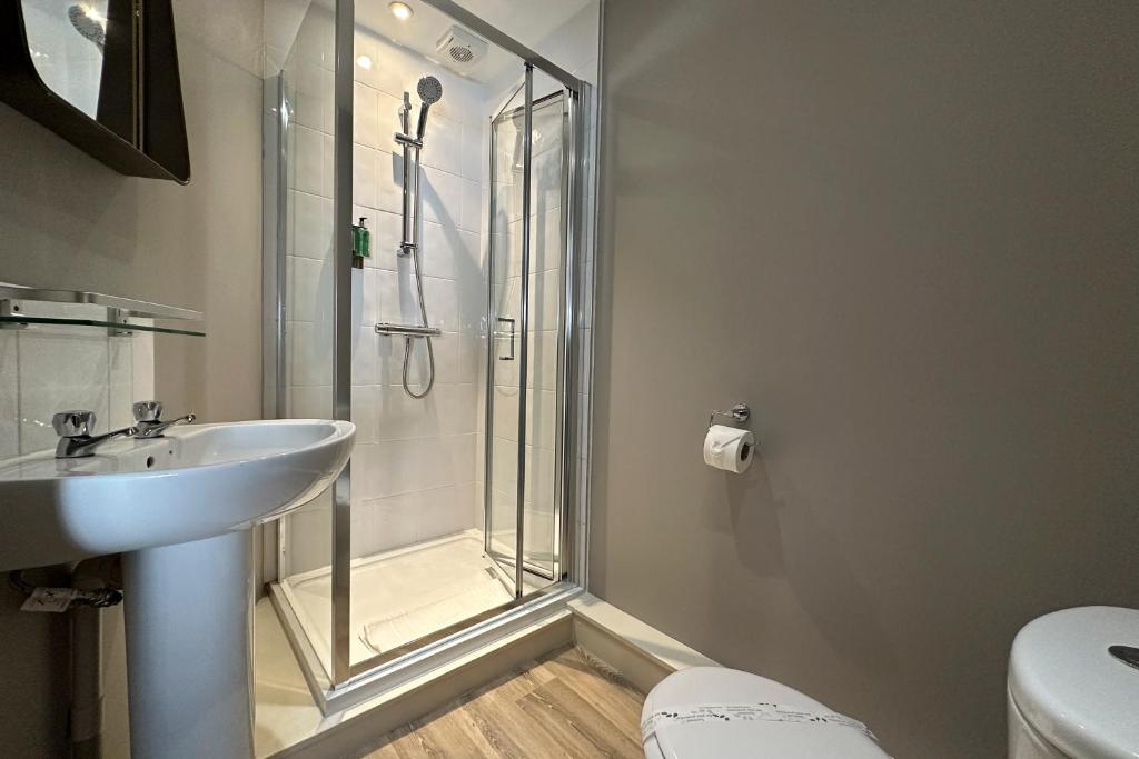 a bathroom with a shower and a sink and a toilet at The Lobster in Sheringham