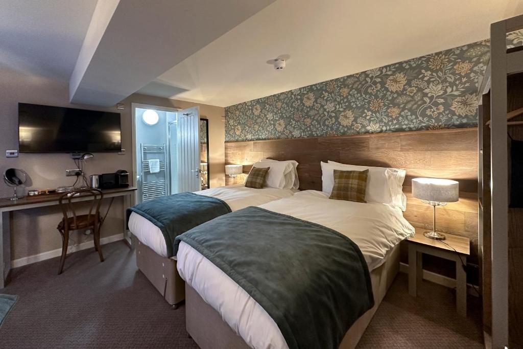 a hotel room with two beds and a flat screen tv at The Lobster in Sheringham