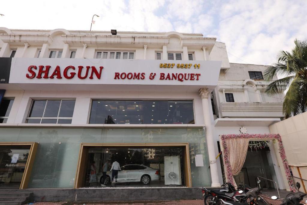 una tienda frente a un edificio con un coche en la ventana en Hotel Shagun Rooms & Banquet, Surat, en Surat