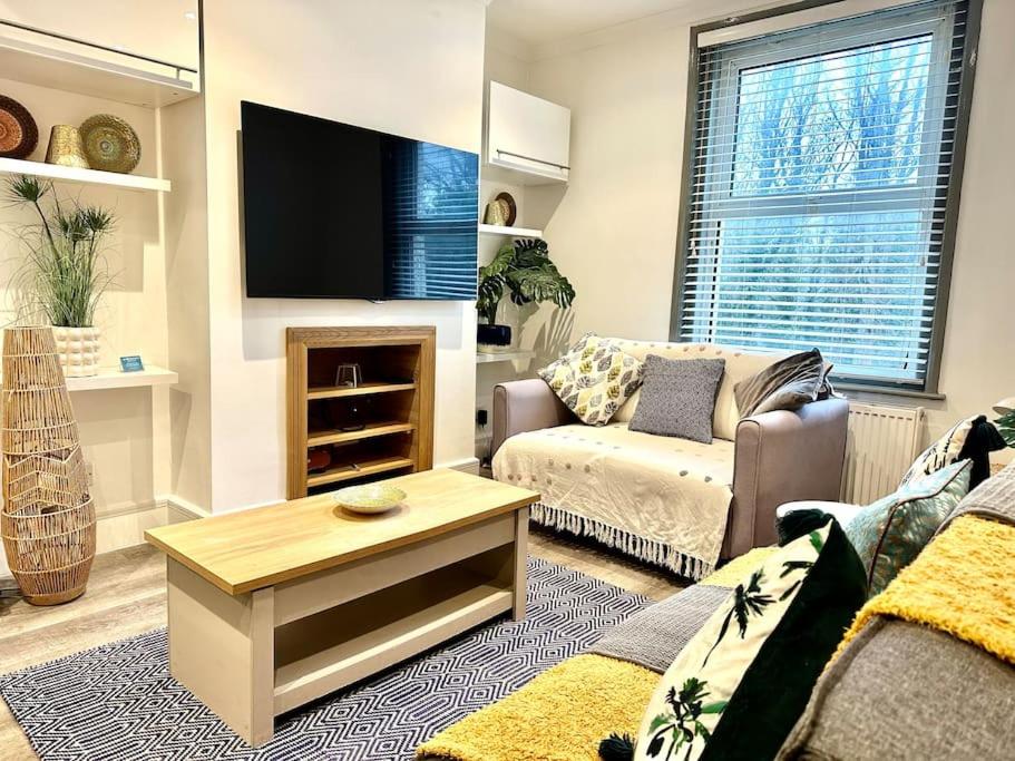 ein Wohnzimmer mit einem Sofa und einem Flachbild-TV in der Unterkunft Modernised cottage Sleeps Six in Ore