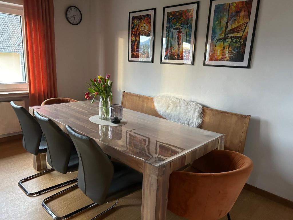 a dining room with a wooden table and chairs at Eifel Ferienwohnung Thiel in Oberstadtfeld
