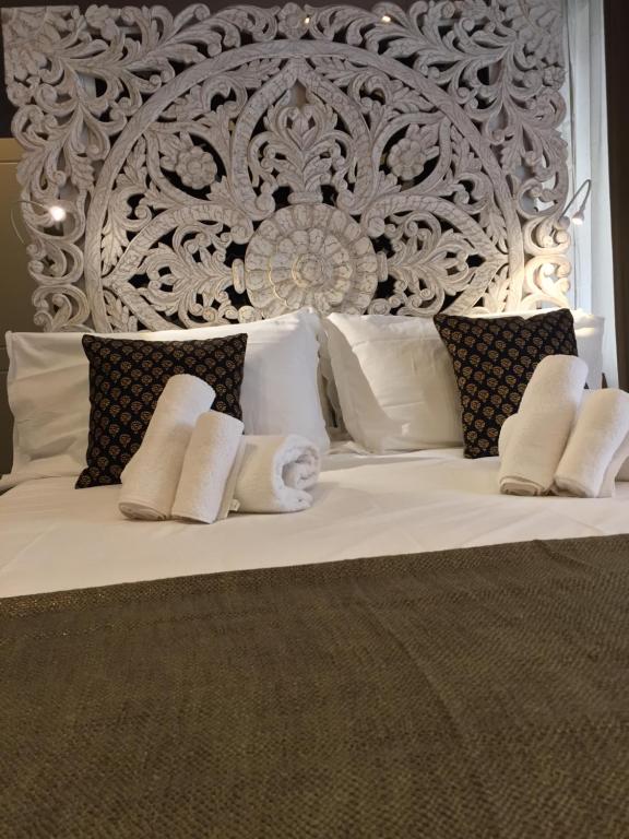 een wit bed met witte kussens en een hoofdeinde bij 29 Venti Luxury in Palermo