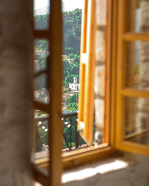 an open window with a view of a mountain at Roots Dhermi in Dhërmi