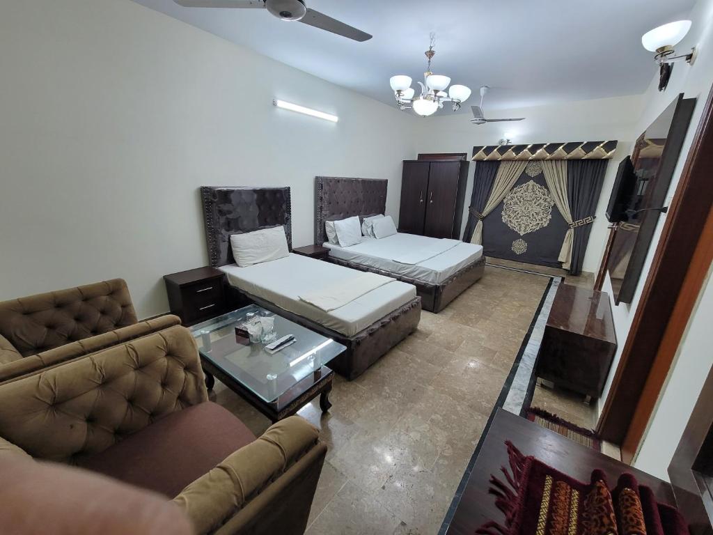 Karachi Family Guest House في كراتشي: غرفة معيشة مع سرير وأريكة
