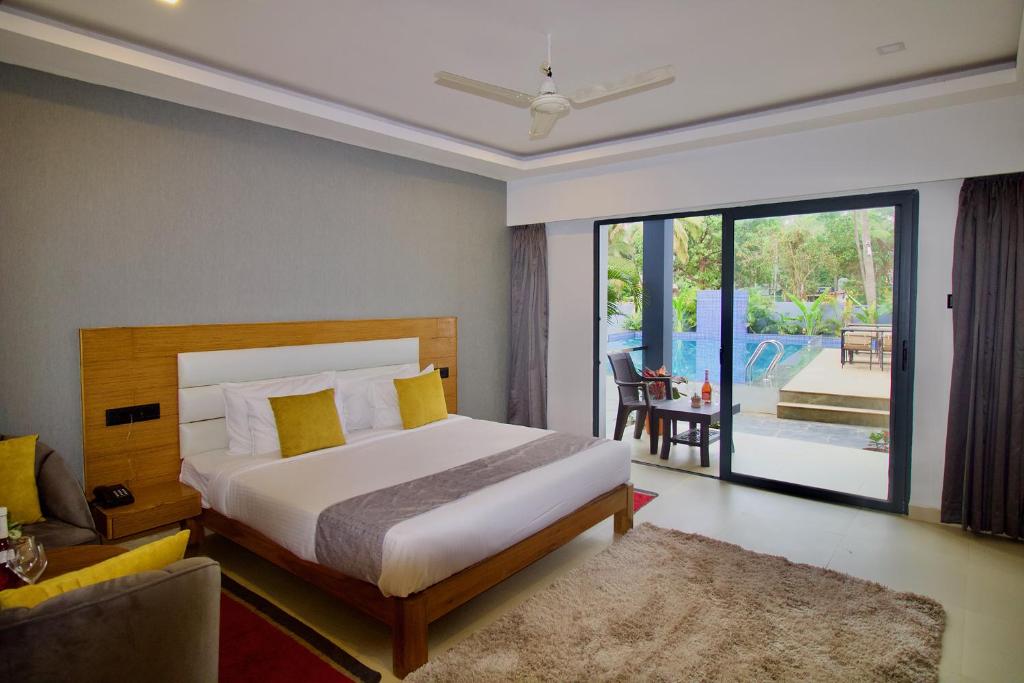 a bedroom with a bed and a living room at FabHotel Resort De Ashvem in Morjim