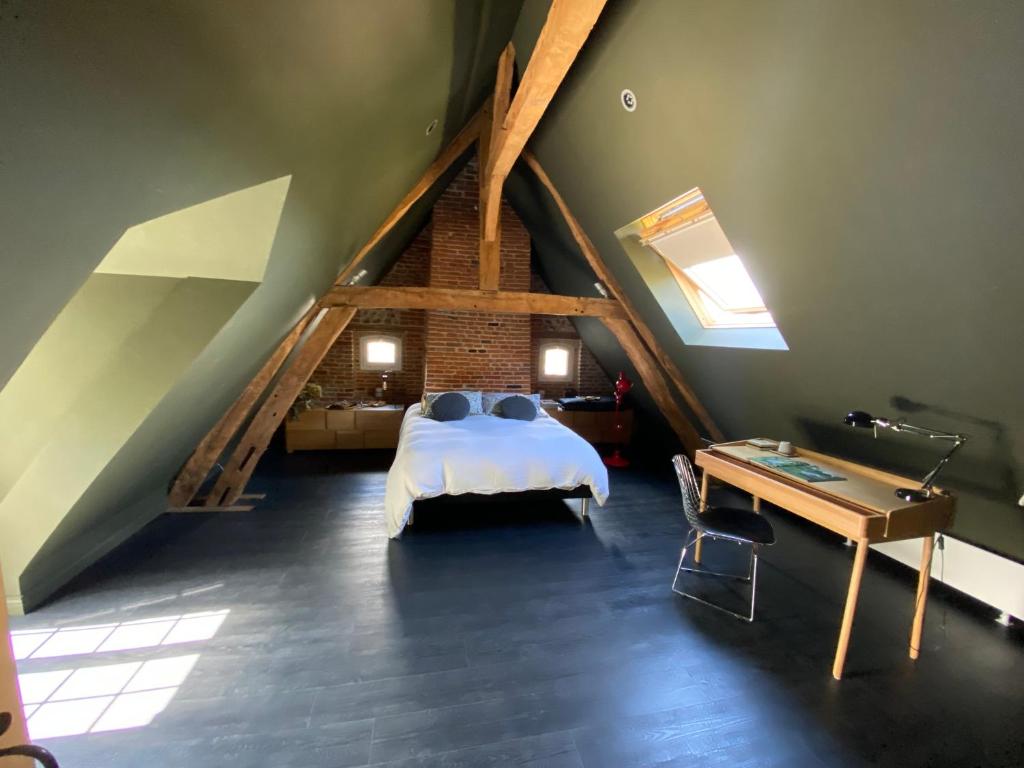 una camera da letto con letto in mansarda di La benjamine a Cany-Barville