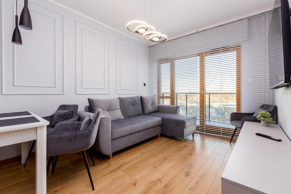 a living room with a couch and a table at Nadmotławie Chic Apartment in Gdańsk