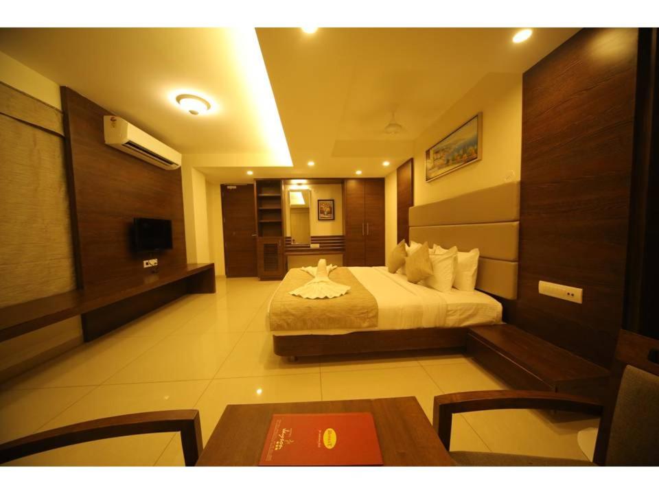 a hotel room with a bed and a table at Hotel Jayson Metoda in Rajkot
