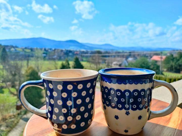 two coffee cups sitting on top of a wooden table at Apartamenty w Beskidach in Górki Wielkie