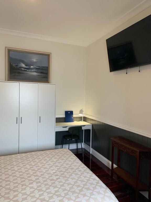 a bedroom with a bed and a desk and a tv at West End Studio 2 in Brisbane
