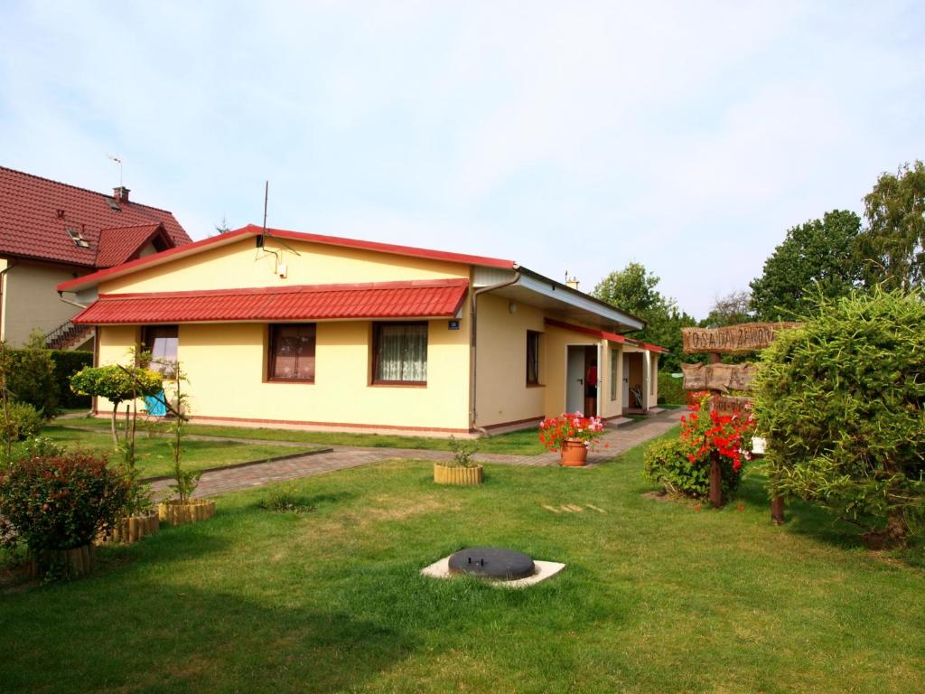 ルビャトボにあるDom wczasowy Fala w Kopalinieの庭の赤屋根の黄色い家