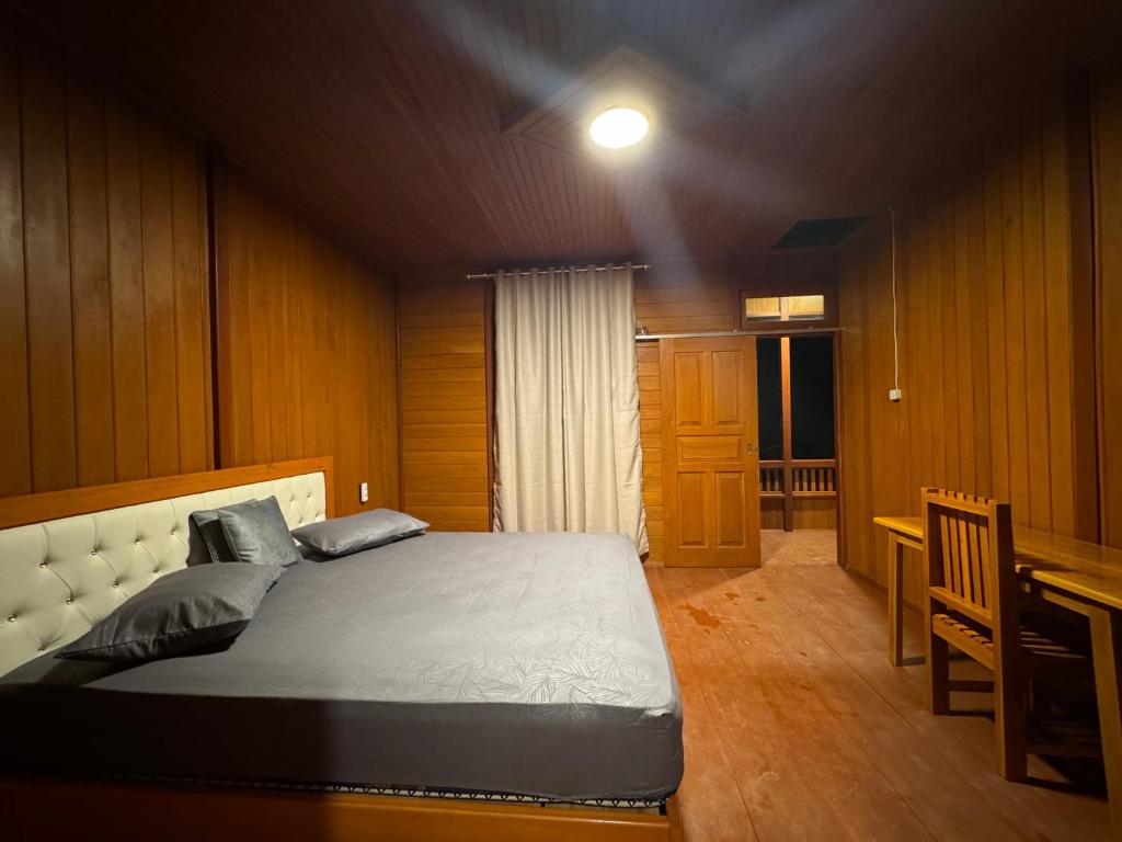 a bedroom with a bed and a desk and a table at MC Bunaken Inn & Dive in Bunaken