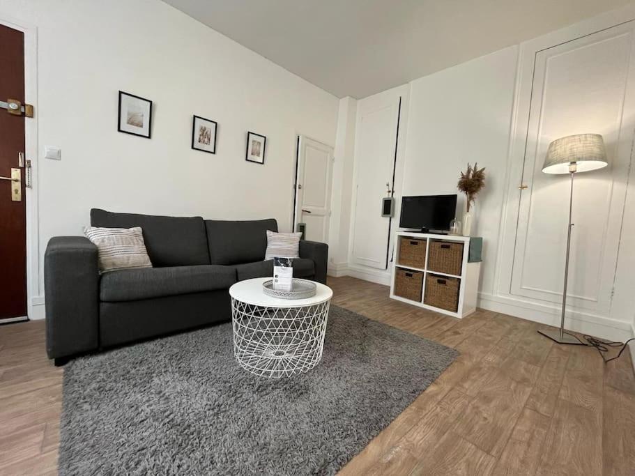 un salon avec un canapé et une table dans l'établissement Le Studio Noir et Blanc, à Fontainebleau