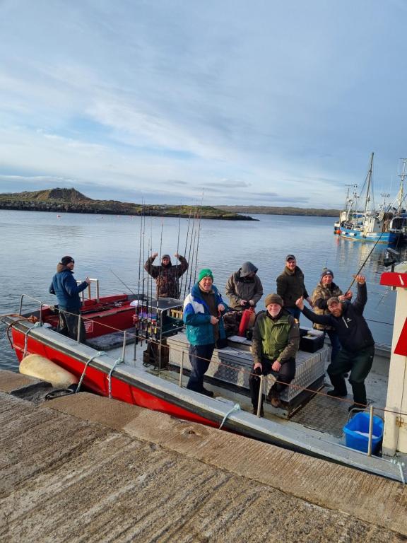 a group of people on a small boat on the water at Burtonport fishing trips in Dungloe
