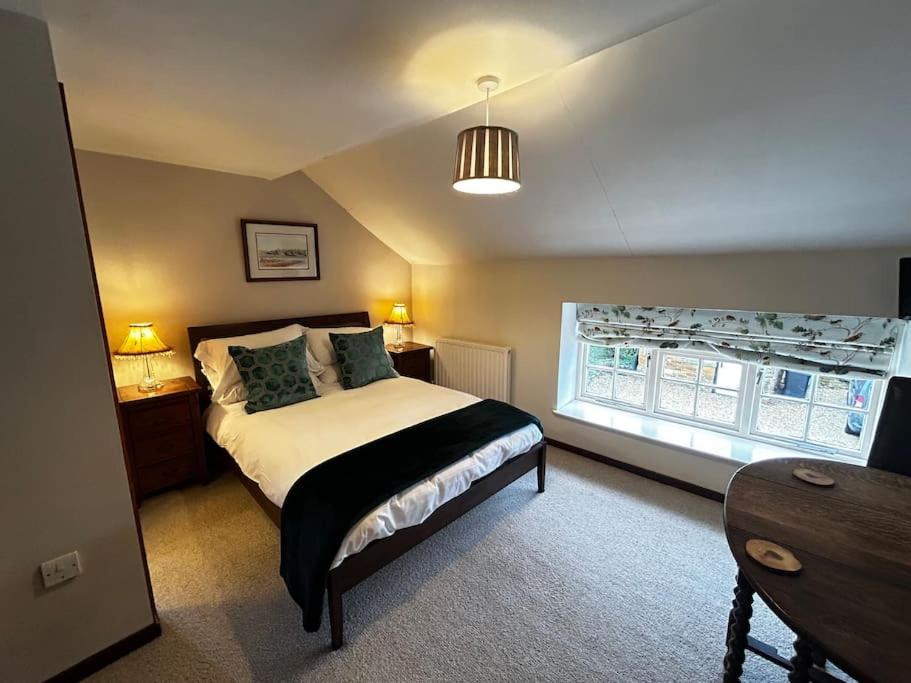 a bedroom with a large bed and a window at Robin in Lyddington