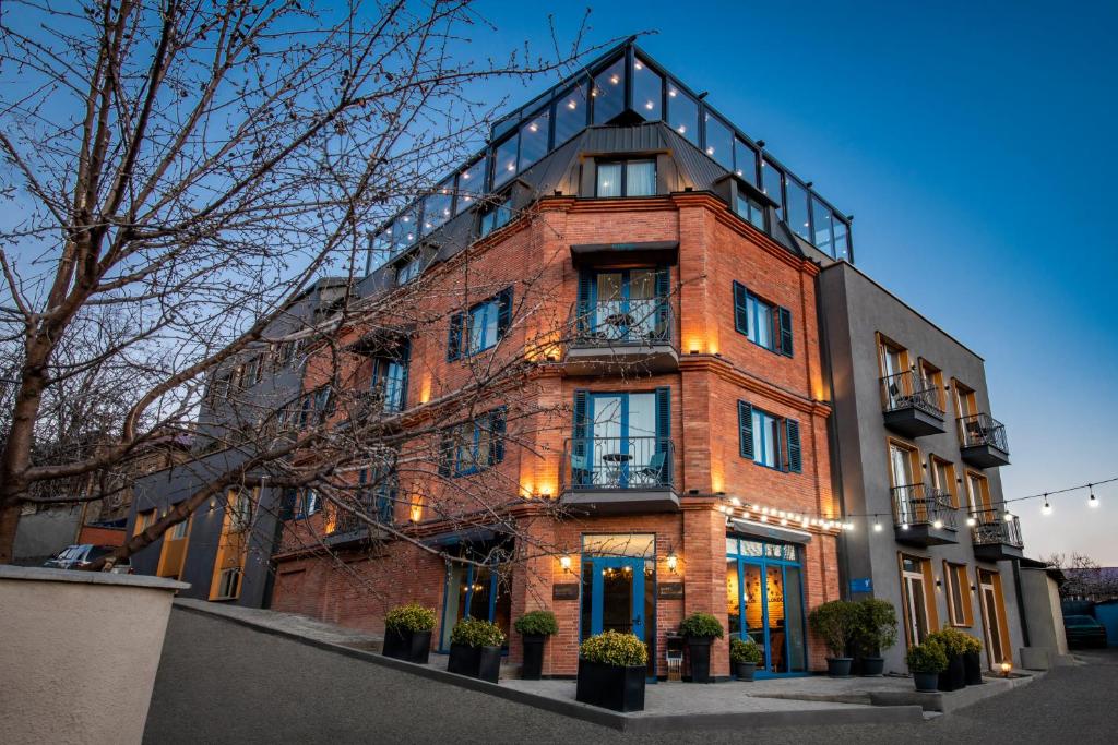 a red brick building with lights on it at Hotel Address 9D in Tbilisi City