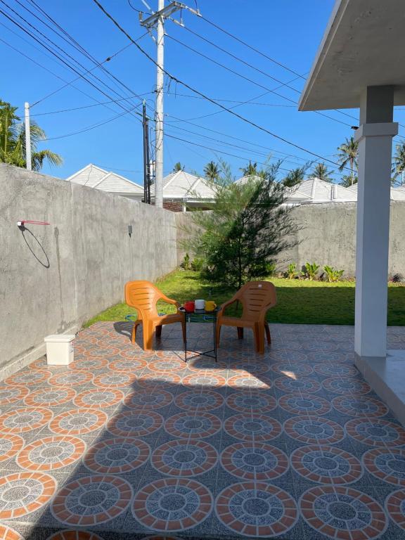 un patio con 2 sillas y una mesa en Breeze House en Prampuan