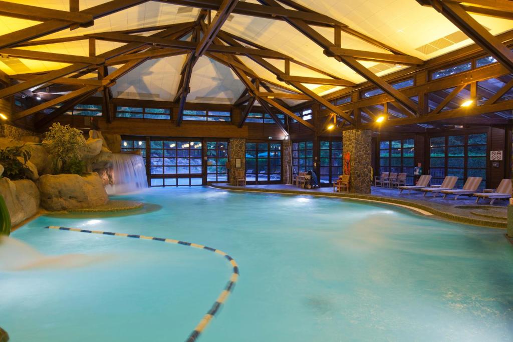 - une grande piscine intérieure dans un bâtiment avec piscine dans l'établissement Disney Sequoia Lodge, à Coupvray