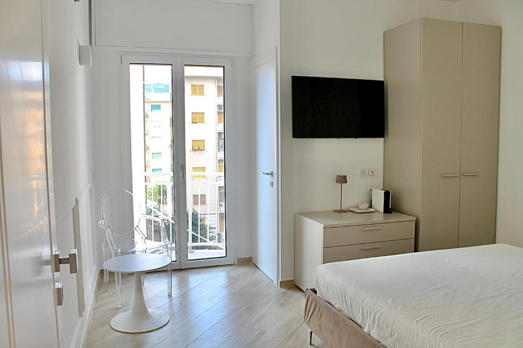 a bedroom with a bed and a desk and a window at La Casa Del Molo in Finale Ligure