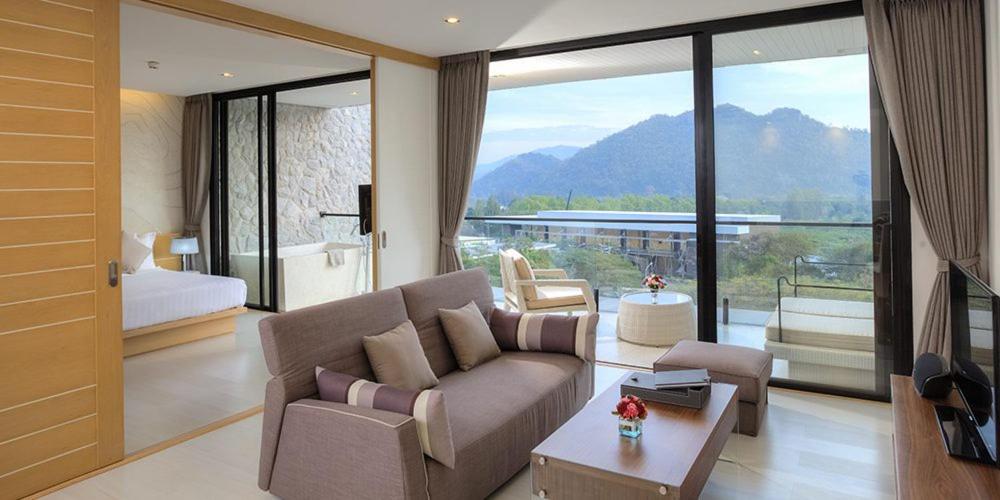 een woonkamer met een bank en een slaapkamer bij Luxurious Botanica Khao Yai in Khao Yai