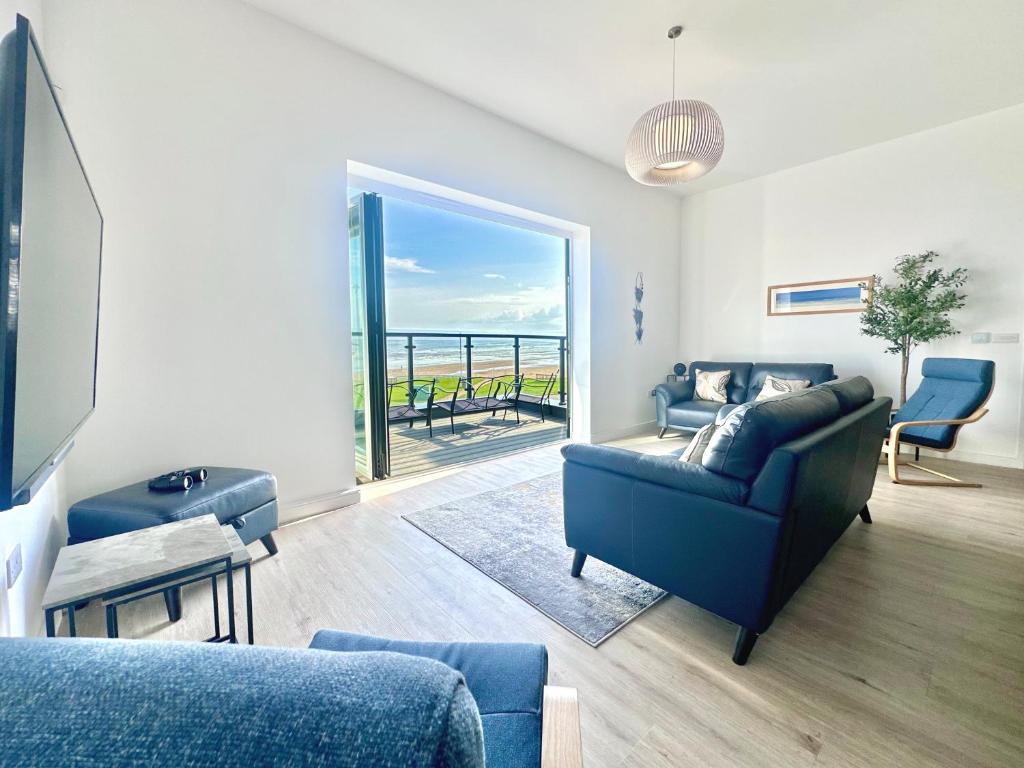 a living room with a couch and a view of the ocean at Shoreside Villa, by the Golf Course in Bridlington