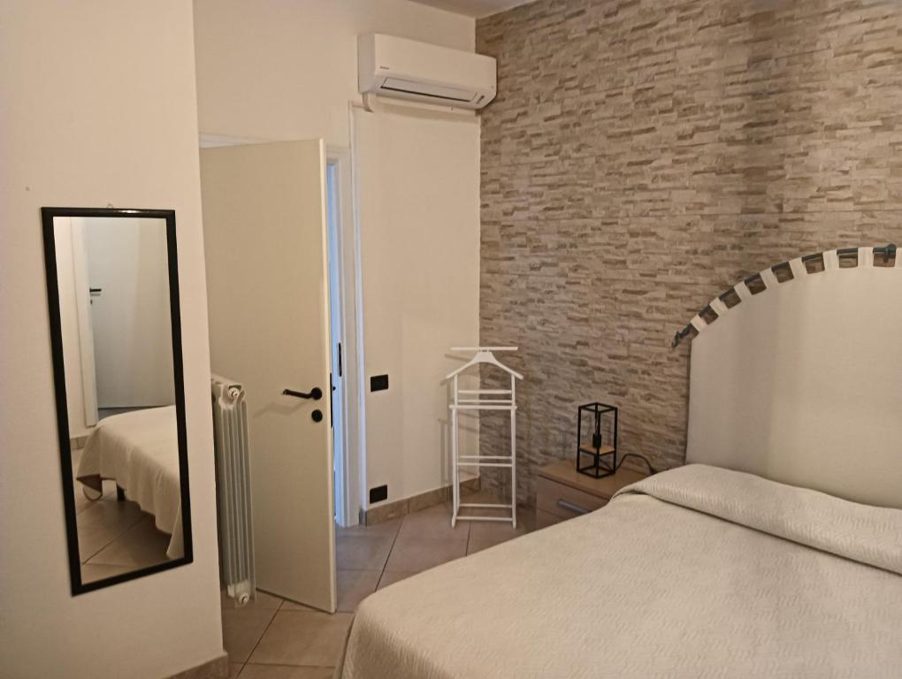 a bedroom with a bed and a brick wall at Domos Le Due Tuie in Piscinas