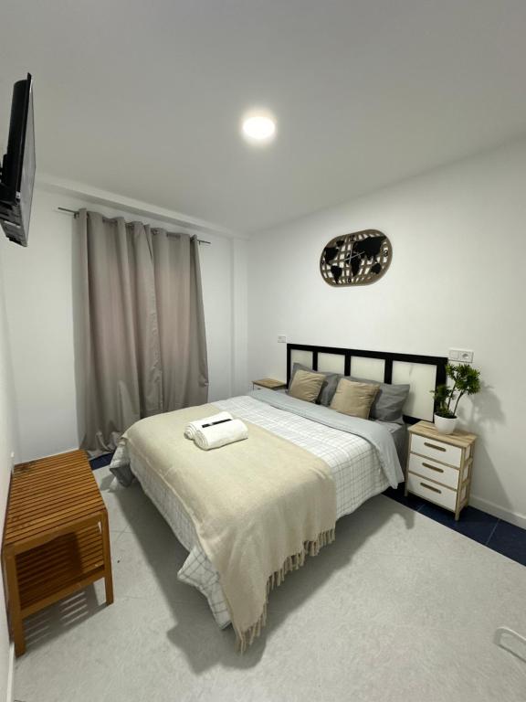 1 dormitorio con 1 cama grande y 1 mesa en Rooms Mediavilla, en Madrid