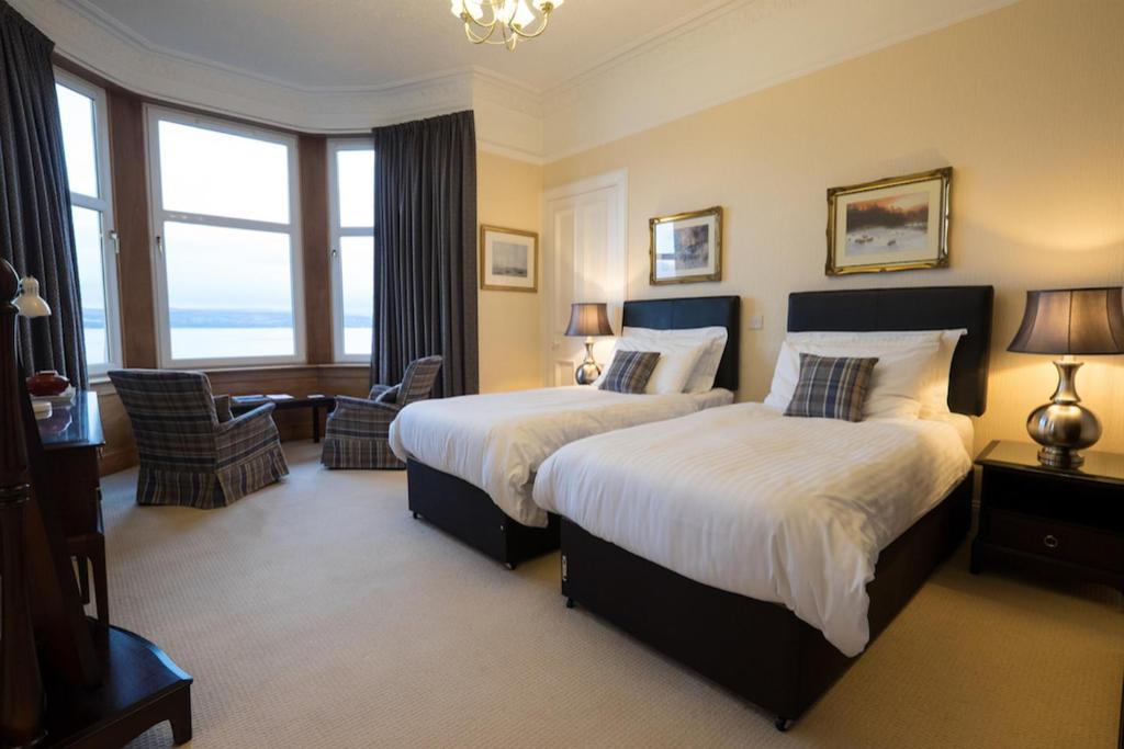 a hotel room with two beds and a large window at The Cedars Guest House in Dunoon