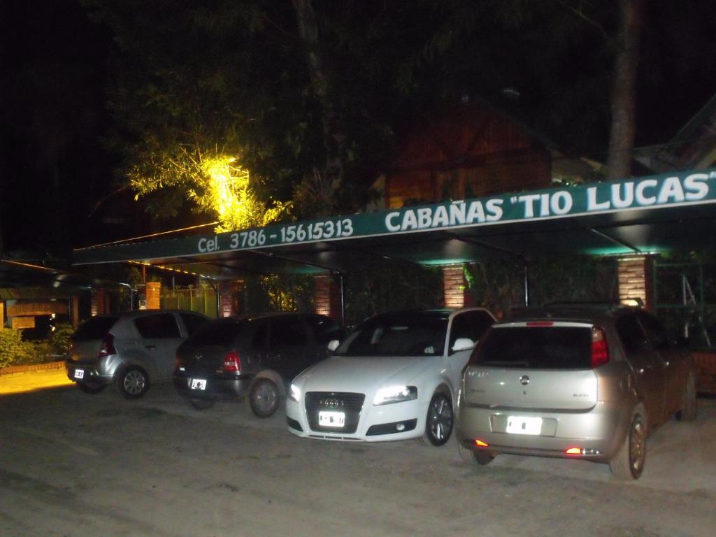 a group of cars parked in a parking lot at night at Hotel Cabañas Tio Lucas in Ituzaingó