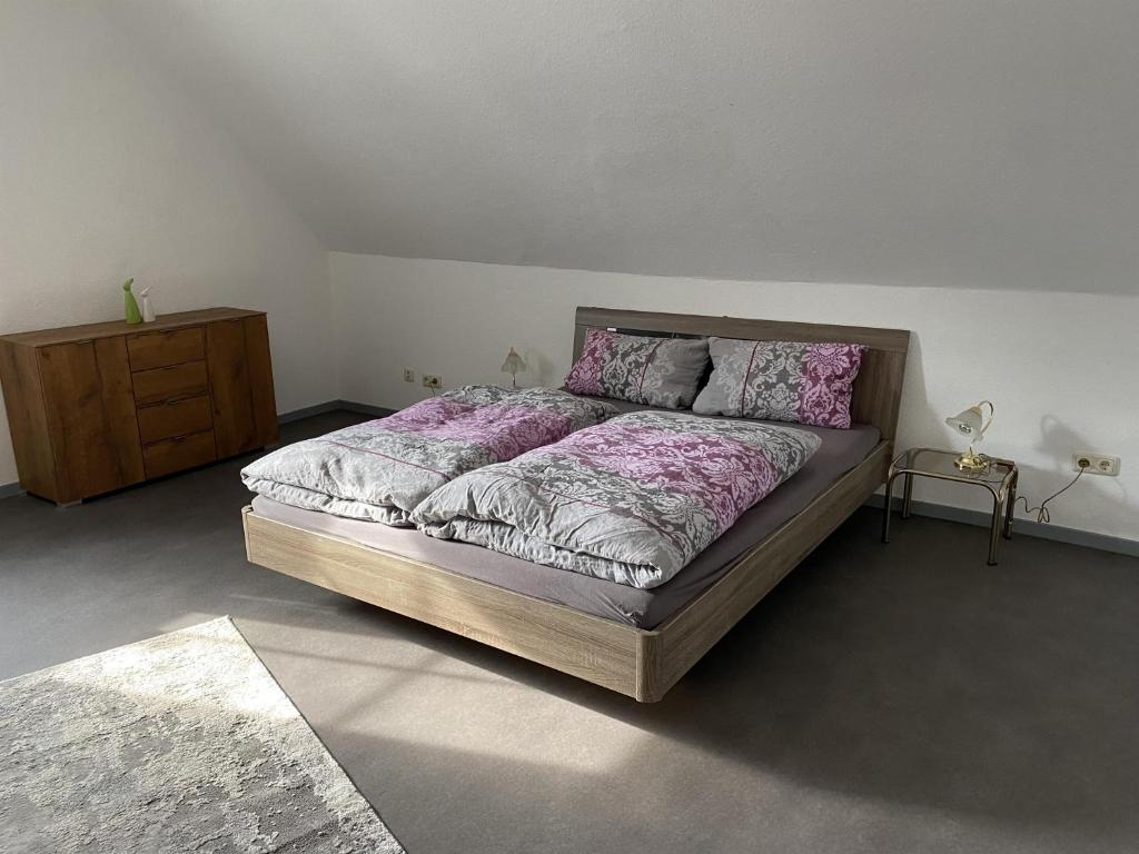 sypialnia z dużym łóżkiem i drewnianą komodą w obiekcie Ferienwohnung Rosch w mieście Konz