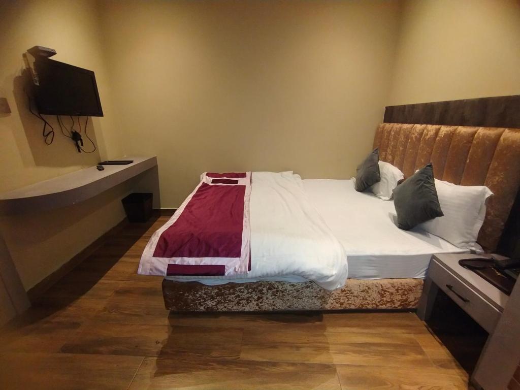 a bed in a room with at Hotel Palassio in Kānpur