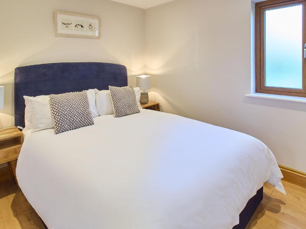 ein Schlafzimmer mit einem großen weißen Bett und einem Fenster in der Unterkunft Host & Stay - Oak Barn in Ashford